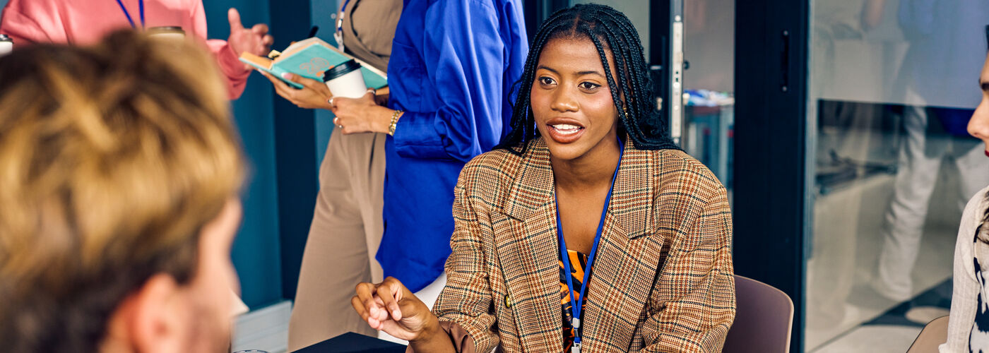 Professional working woman sat at a desk deep in conversation